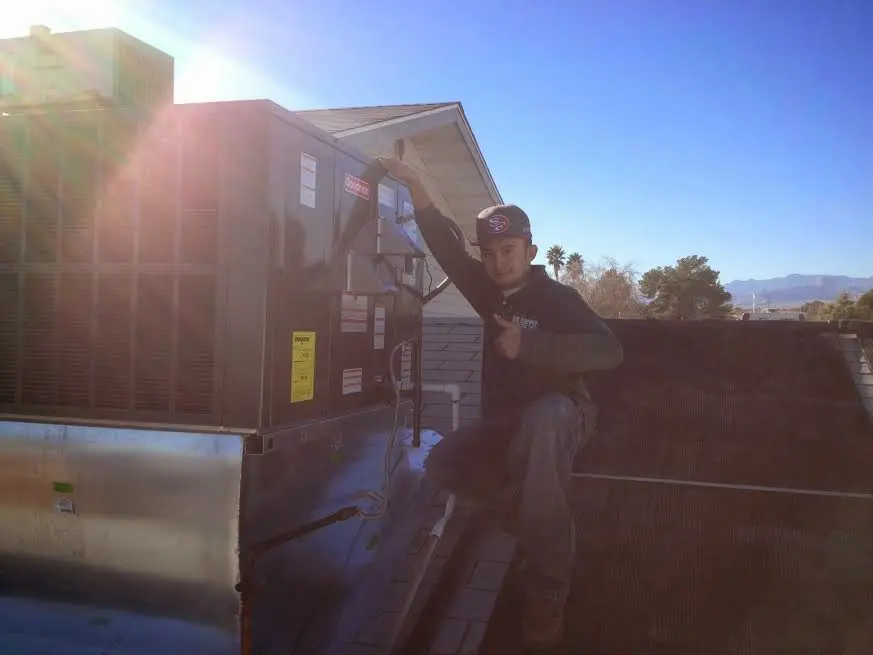 HVAC technician performing Boiler Repair on a rooftop unit in Lake Arrowhead